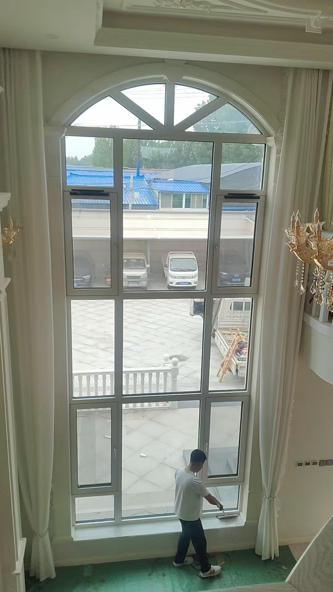 Arched aluminum casement window in a finished interior