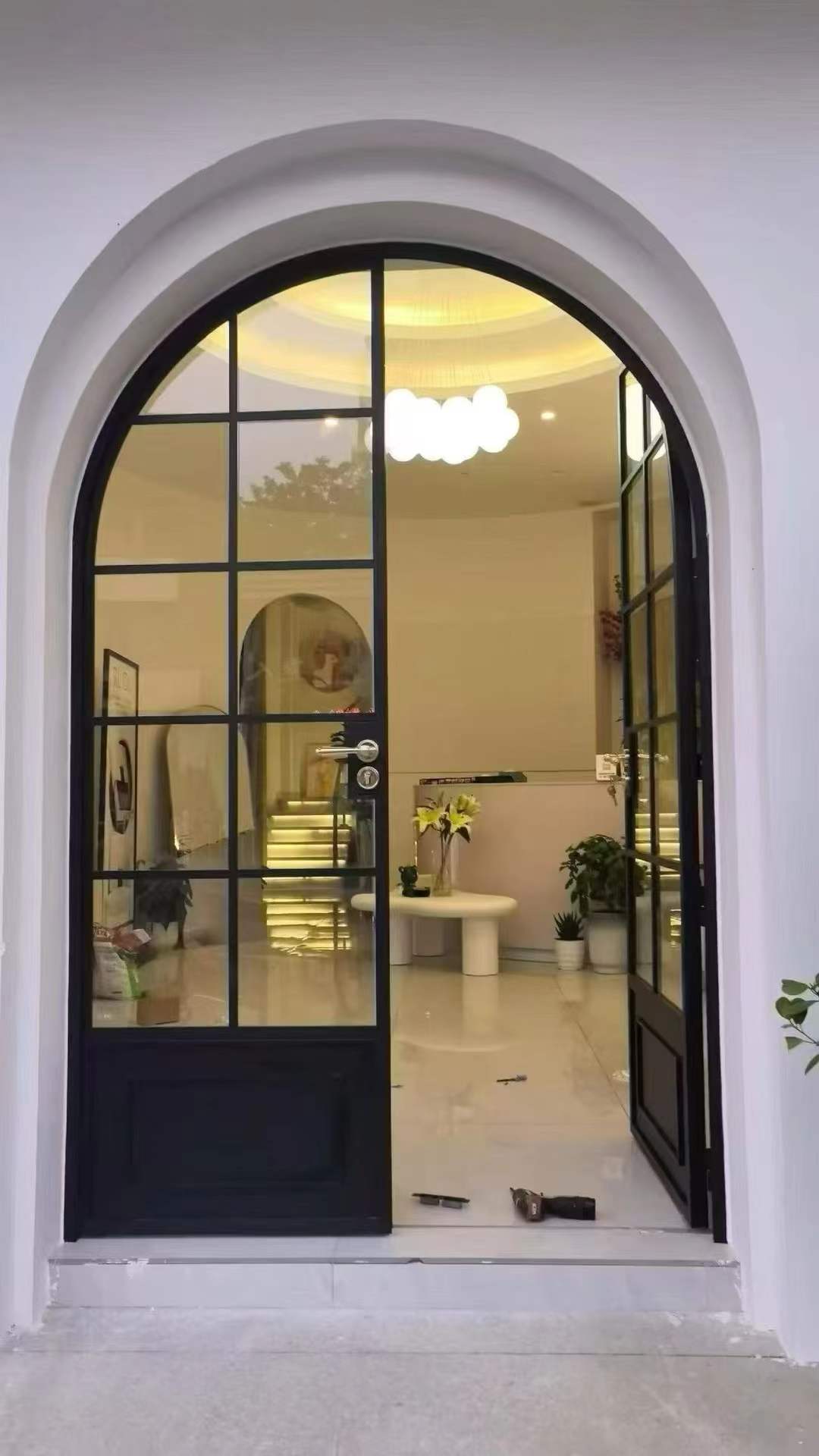 Arched black framed glass entry door